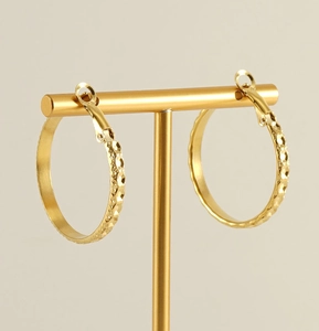 Detailed view of gold-tone textured hoop earrings on a T-bar jewelry display stand