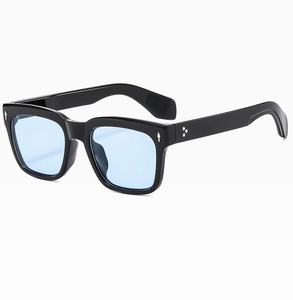 Detail of vintage thick black frame sunglasses with blue lenses and silver star rivets