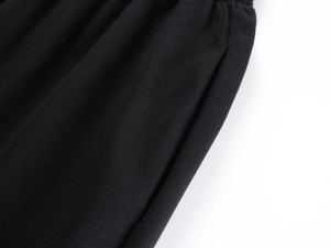 Macro shot of elastic gathered waistband and side pocket on black high waist sweatpants
