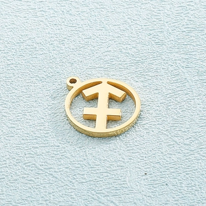 Detail of a round gold zodiac pendant featuring a minimalist cutout on a blue background