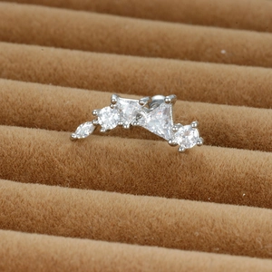 Vue macro d'un piercing d'oreille courbé en acier avec cinq zircons étincelants