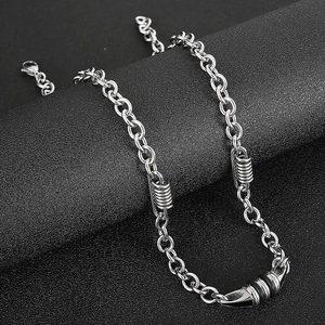 Macro shot of silver stainless steel chain with spring ring and black cone pendant detail