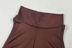 Detailed macro shot of the high neckline and stitching on a dark brown sleeveless dress