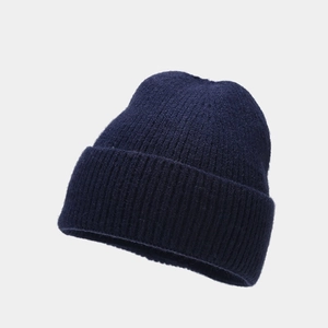 Close-up of dark blue knit beanie showing vertical ribbed texture and thick cuffed edge