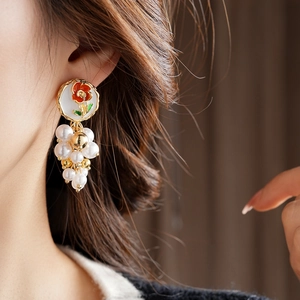 Détail de boucle d'oreille vintage fleurie avec perles, placage or et émail coloré