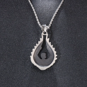 Detailed view of silver angel wing pendant with black silhouette on twisted chain