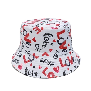 Détail d'un chapeau bob blanc avec texte LOVE rouge et motifs imprimés de cœurs
