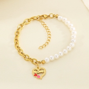 Detail of gold chain and pearl bracelet with Mama heart charm and red pink accents