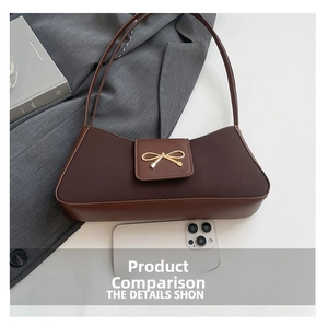 Detailed view of brown baguette bag with golden bow buckle and smartphone size comparison