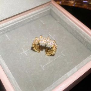 Detail of 18k gold plated open ring with square zircons in a pink jewelry box