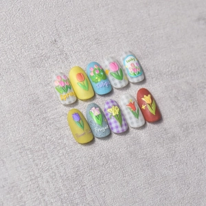 Detail of 3D embossed tulip nail charms featuring matte finish and colorful hand-painted art