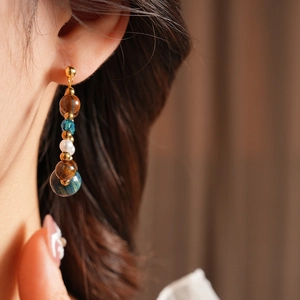 Detailed view of vintage beaded earrings with tiger eye, blue crystal and white pearls