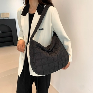 Detail of black quilted puffer tote bag with square stitching on lightweight material