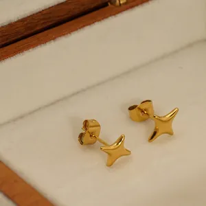 Polished 18k gold plated stainless steel four-point star stud earrings in a wooden box