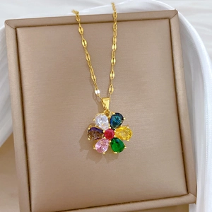 Close-up of golden rotating flower pendant with colorful gems on a premium jewelry box