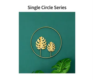 Detailed close-up of golden Monstera leaf inside a circular iron wall art sculpture