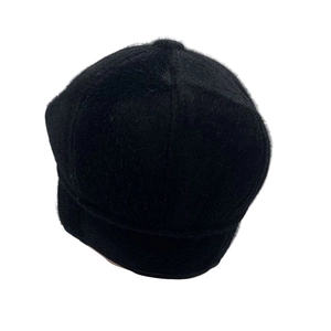 Detail of black faux fur winter newsboy hat featuring plush texture and warm ear flaps