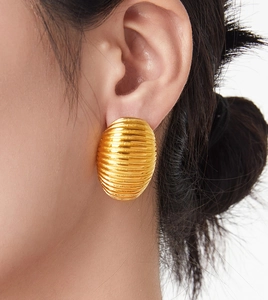 Detailed close-up of a gold-plated titanium steel earring with textured linear pattern