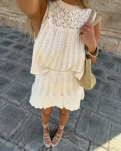 Primo piano di set in maglia crochet beige con motivi traforati e coulisse in vita