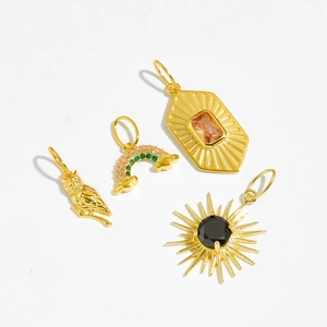 Detailed flat lay of four gold s925 silver pendants including owl and rainbow sun charms
