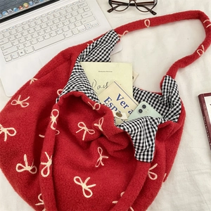 Détail du sac cabas en peluche rouge avec broderie nœud et doublure vichy avec objets divers