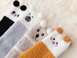 Detail of soft coral fleece over-knee socks with cute cartoon animal faces and 3D ears