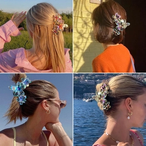 Outdoor lifestyle view of women wearing a frosted flower claw clip with iridescent finish