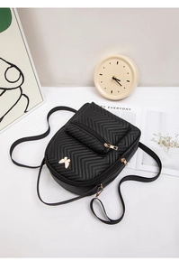 Detalle de mochila de cuero PU acolchado negro con adorno de mariposa dorada y cierre