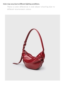 Detailed view of glossy burgundy pleated dumpling bag with silver hardware and strap