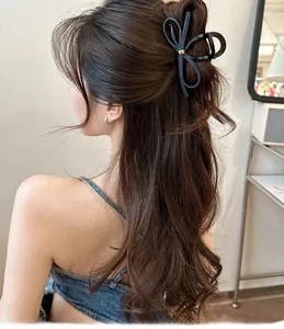 Détail de la pince à cheveux en denim avec boucle dorée pour coiffures demi-attachées