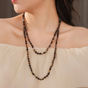 Detail of bohemian long double-layered beaded necklace with natural agate on model