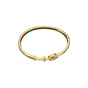 Gold plated hinge bangle featuring a hollow peace sign and zircon studded cross element