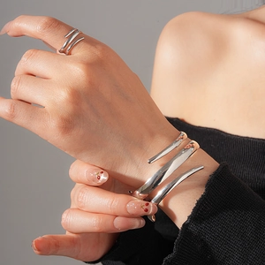 Minimalistisches silbernes Spiralarmreif- und Ring-Set getragen von Model bei sanftem Licht