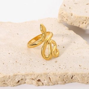 Vista macro dell'anello a serpente placcato oro 18K su una superficie di pietra beige naturale