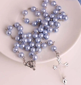 Détail d'un chapelet de perles bleues avec croix en argent et médaille de la Vierge Marie