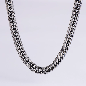 Detailed close-up of polished silver steel Cuban link chain with vintage blackened texture