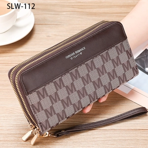 Close-up of brown leather long wallet with double zippers and hand strap on a desk