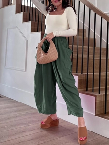 Dettaglio di pantaloni larghi a vita alta verde scuro con vita elastica a pieghe casual
