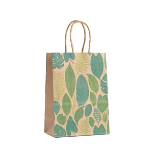 Eco-friendly kraft paper gift bag with tropical green leaf patterns and twisted rope handles