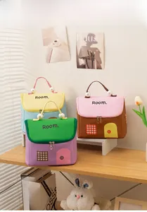 Dettaglio di borse da trucco a forma di casa con manici di perle e stampe decorative carine