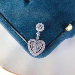 Micro-pavé heart pendant necklace with baguette-cut and round diamonds on blue velvet