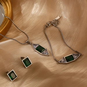 Parure bijoux argentée élégante avec émeraudes, collier et boucles sur soie