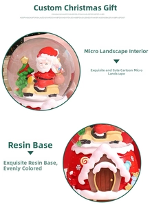 Detail of Christmas snow globe featuring Santa on a motorcycle and a resin cottage base