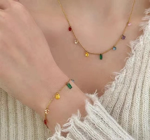 Detail of gold chain necklace and bracelet set with multi-colored zirconia stones