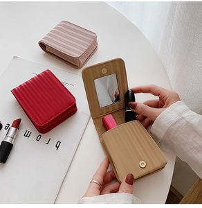 Close-up of portable leather mini makeup bags with built-in mirrors in assorted colors