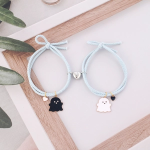 Detail of light blue braided bracelets with magnetic heart clasp and ghost pendants
