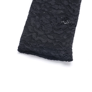 Close-up of intricate black lace texture and fine mesh patterns on a dress sleeve