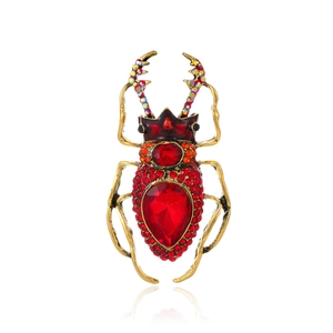 Punk beetle brooch in gold finish with red crystals and colorful rhinestones on white background
