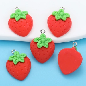 Macro detail of red resin strawberry charms showing textured front and smooth back