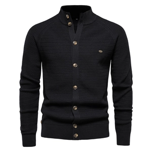 Close-up of black waffle knit cardigan texture with stand collar and button details